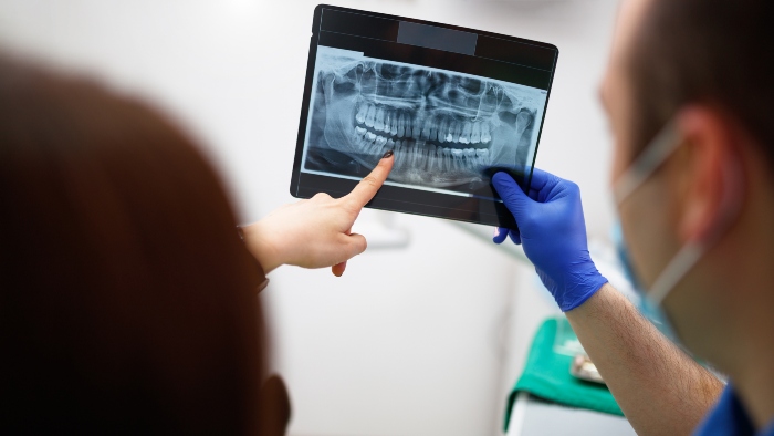 A dentist showing the patient her dental x-ray in Portage, MI