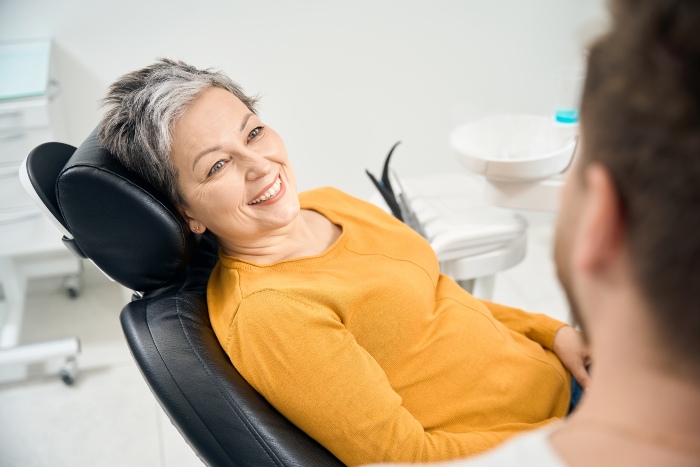 Smiling woman at the dentist for preventative care in Portage, MI